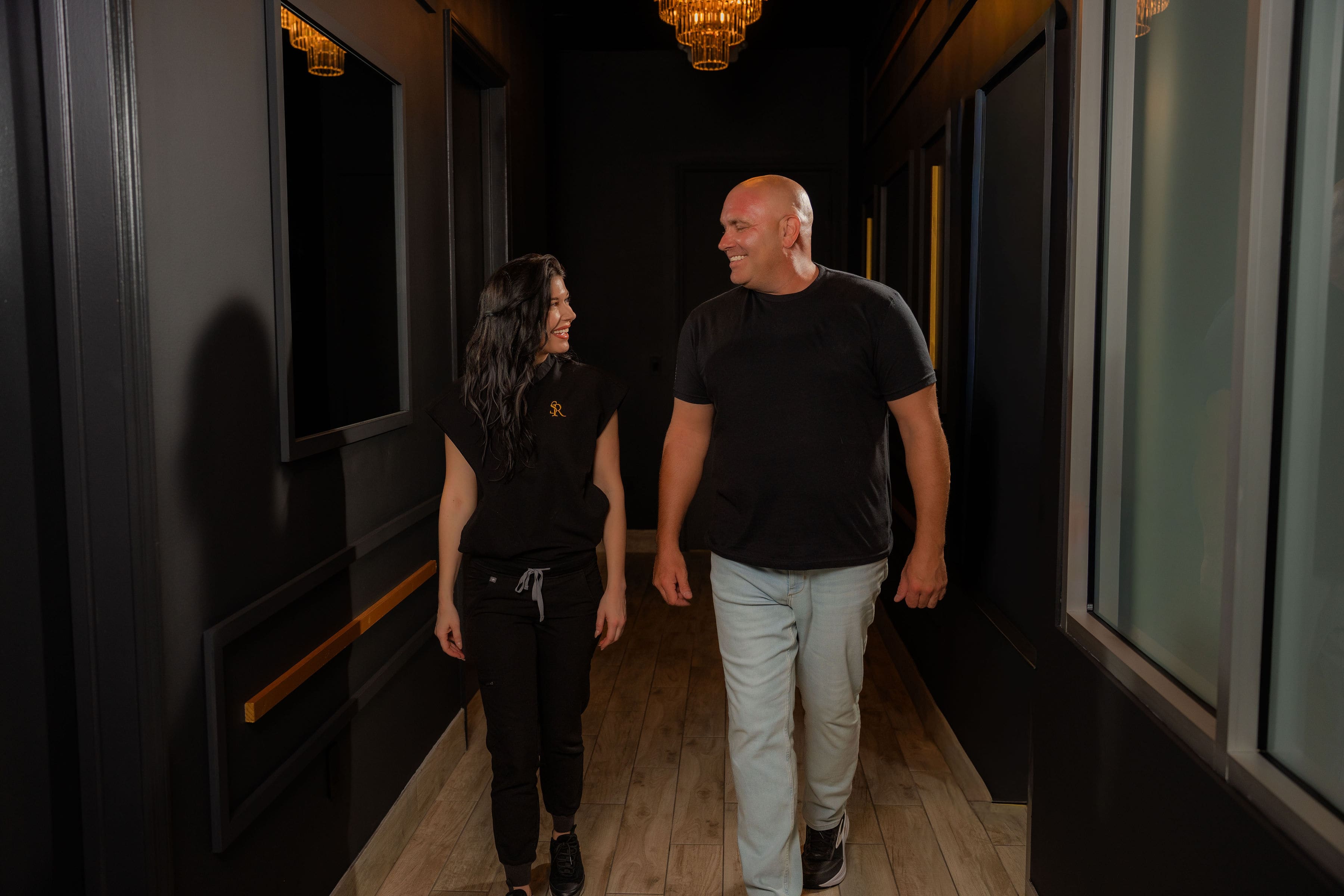 Erica Current and a client walking down a hallway at The Skin Room