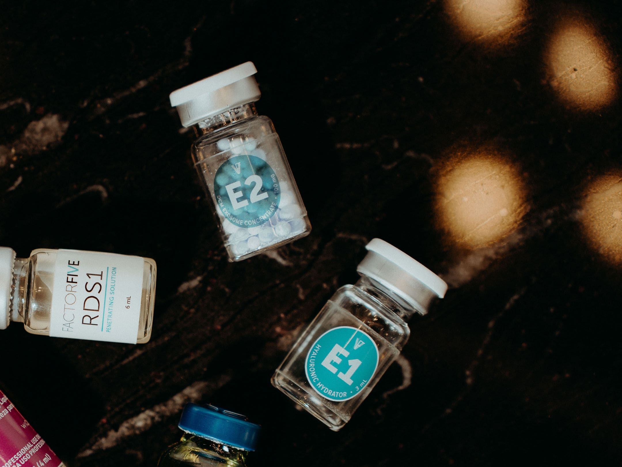 The two Exofecta vials, E1 and E2, on dark marble