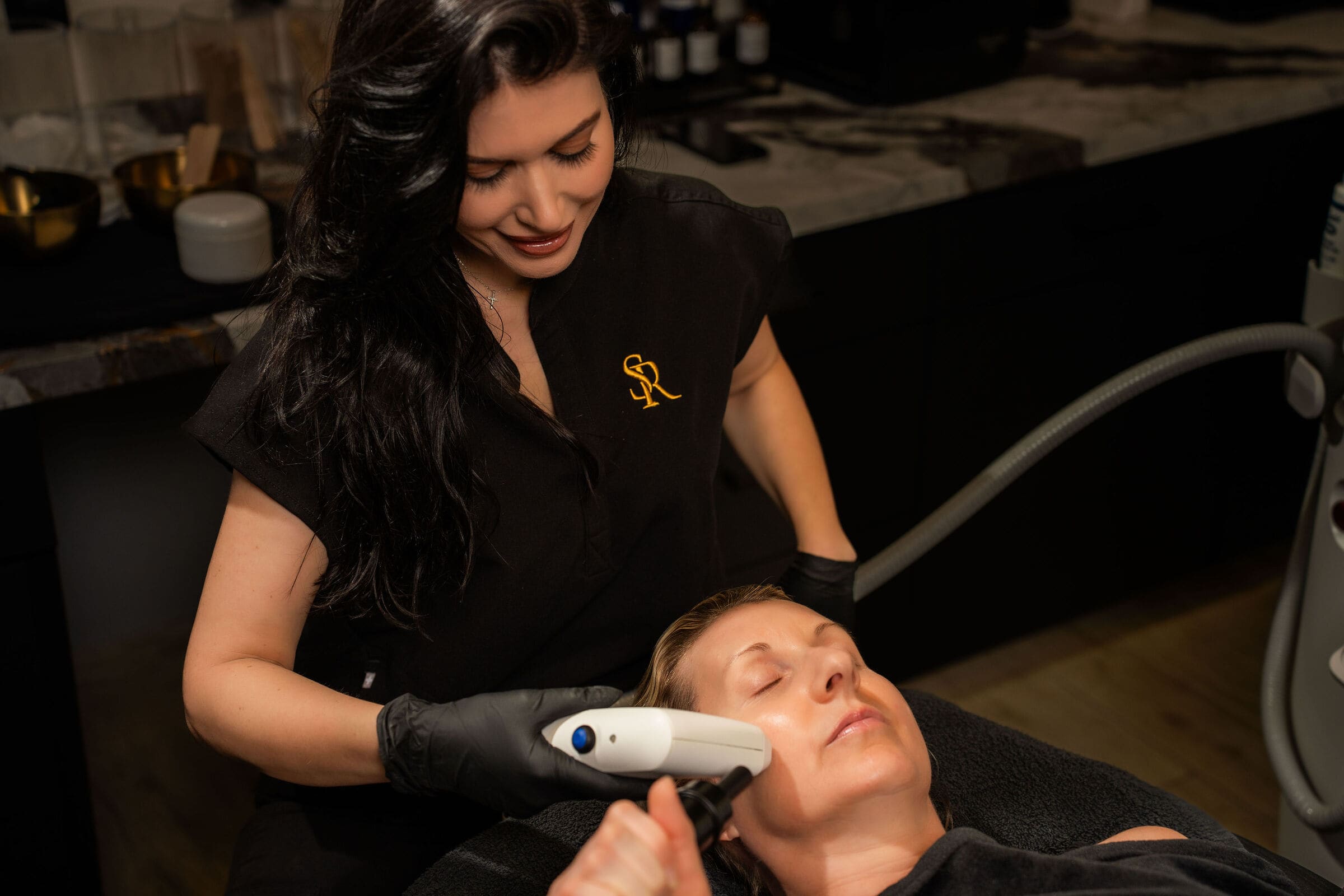 A provider treating a client's face with the Sofwave handpiece